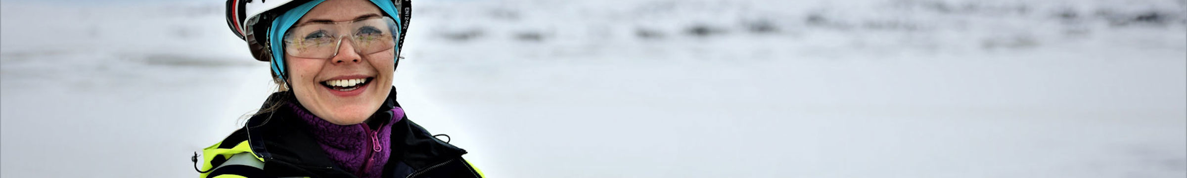 Woman smiling in work attire in snowy mountains